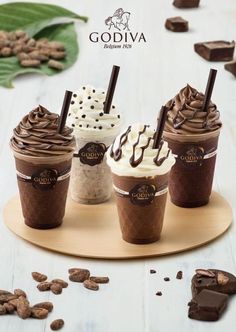 four different kinds of ice creams on a wooden tray with chocolate chips and leaves