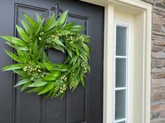 a green wreath on the front door of a house