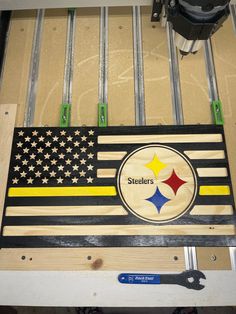 a pittsburgh football flag made out of wooden planks and metal bars with tools on it