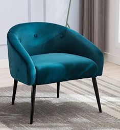 a blue chair sitting on top of a rug next to a white wall and window