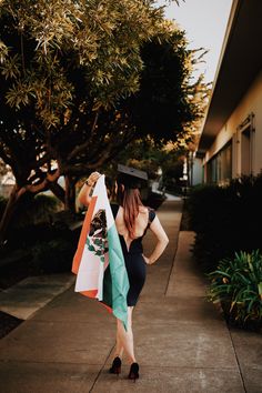 a woman carrying shopping bags down a sidewalk