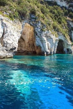 the water is crystal blue and there are some cliffs in the backgrouds