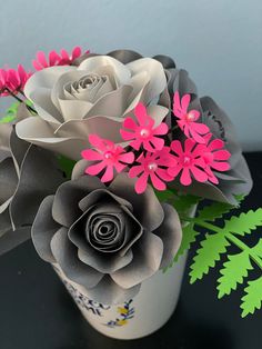 an arrangement of paper flowers in a vase