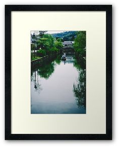 a small boat traveling down a river surrounded by trees