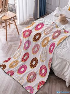 a bed covered in a blanket with donuts on it