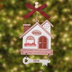 a christmas ornament with a house and key hanging from it's side