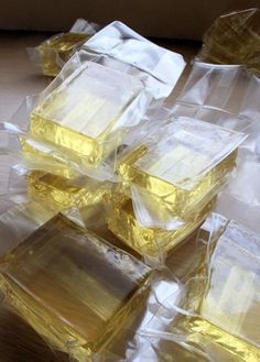 several square pieces of yellow liquid sitting on top of plastic wrapped in cellophane