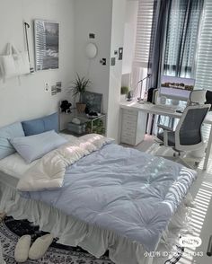 a bed sitting in a bedroom next to a desk with a computer on top of it