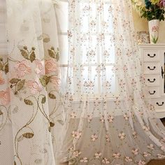 the curtains in this room are decorated with pink flowers and white laces on them