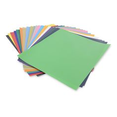 various colors of paper are stacked on top of each other, with one green sheet in the middle