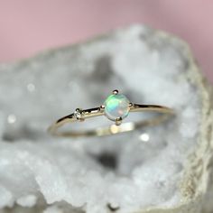 Every hero needs a sidekick...With our "Sidekick" ring in 14K gold, you can feel super all the time! Center opal is accented on one side by a tiny diamond. Super cute! - Australian opal measures 4mm - 1.3mm round band - 1.3mm diamond - Available in solid 10K or 14K gold For our moonstone "Sidekick" ring click here: https://www.etsy.com/listing/594357023/14k-moonstone-side-diamond-ring?ga_search_query=sidekick&ref=shop_items_search_1 For our amethyst "Sidekick" ring click here: https://www.etsy.c Astrology Jewelry, Opal Diamond Ring, Amethyst And Diamond Ring, Ring Opal, Zierlicher Ring, Cabochon Ring, Tiny Diamond, Ring Dainty, Opal Ring