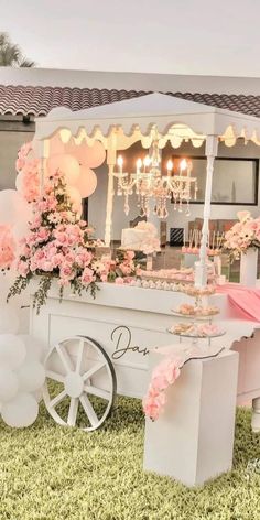 an ice cream cart decorated with pink flowers and balloons