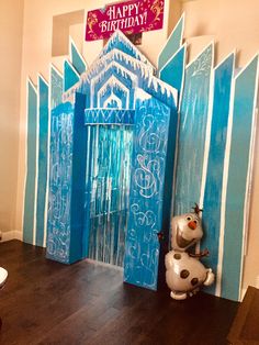 a frozen world birthday party with an ice castle and frosty door, balloons and decorations