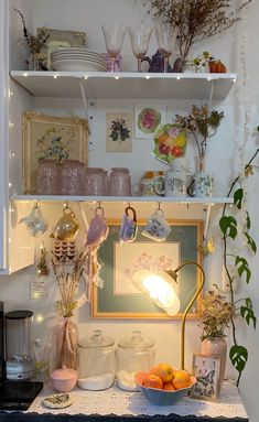 a kitchen counter topped with lots of clutter and dishes on top of it's shelves