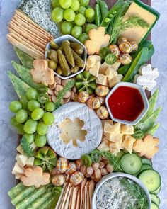 a platter filled with cheese, crackers and vegetables