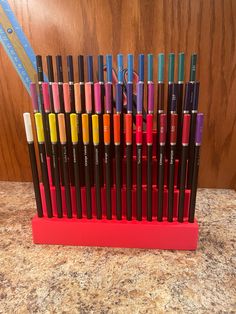 there are many different colored pencils in the holder on the counter top, and one is full of them