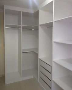 an empty walk in closet with white shelves