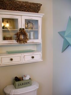 a bathroom with a star on the wall above it and an open cabinet over the toilet