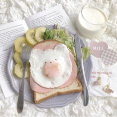 a plate with an egg, ham and banana on it next to a glass of milk