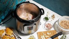 an open crock pot sitting on top of a table filled with food