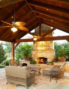 a covered patio with wicker furniture and an outdoor fireplace