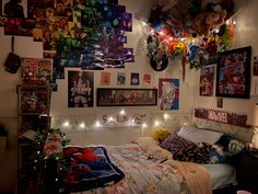 a bedroom with many pictures on the wall and lights strung from the ceiling above it