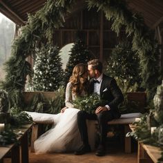 a bride and groom sitting on a bench in front of christmas trees at their wedding