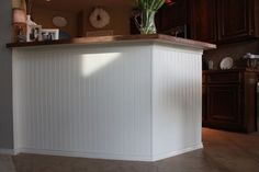 a kitchen with a white counter top and wooden cabinets