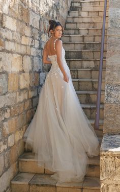 a woman in a wedding dress standing on some steps