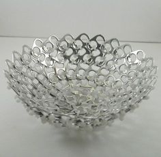 a silver bowl sitting on top of a white table