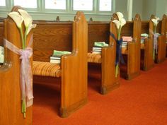 the pews are decorated with flowers and ribbons