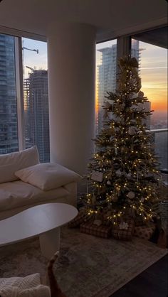 a living room filled with furniture and a christmas tree in front of a large window