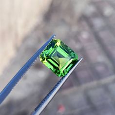 a green diamond sitting on top of a metal pole