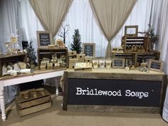 a table topped with lots of different types of soaps next to wooden crates and boxes