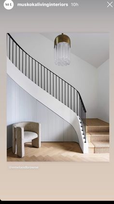 a white staircase with a chandelier hanging from the ceiling next to a wooden floor