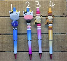 four pens with different animals on them are lined up in front of a wooden sign