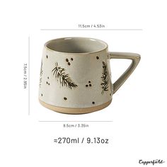 a white coffee mug with pine branches on it and measurements for the cup, which has been