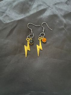 Based on the popular anime, My Hero Academia, these Denki Kaminari inspired earrings feature a gold tone lightning bolt charm that is paired with a small gold and black crystal. They are secured on a black earring hook that is lead and nickel free. My Hero Academia Earrings, Pokemon Earrings, Hero Anime, Black Earring, Bolt Earrings, Denki Kaminari, Fruit Earrings, Earring Hook, Popular Anime