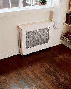 a radiator sitting in front of a window next to a book shelf