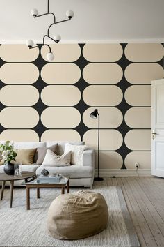 a living room with black and white circles on the wall, couches and coffee table