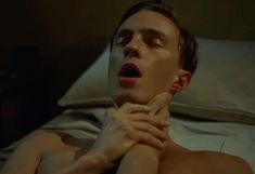 a shirtless man laying in bed with his hands on his chest and mouth open