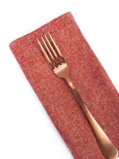 a fork and knife sitting on top of a red napkin