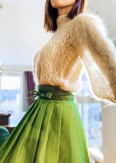 a woman in a green skirt is posing for the camera