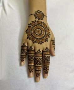 a woman's hand with henna tattoos on it