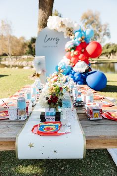 a table set up with balloons and plates