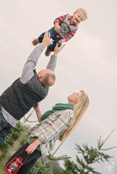 a man and woman holding a baby up in the air