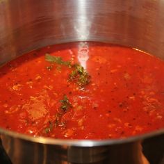 a pot filled with red soup sitting on top of a stove