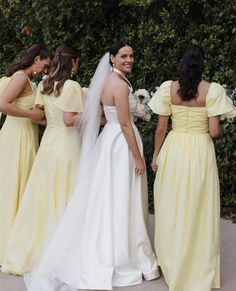 four bridesmaids in yellow dresses standing next to each other