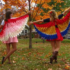 two women dressed in colorful clothing and holding hands with each other while walking through the grass