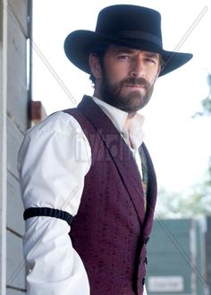 a man with a beard wearing a hat and vest